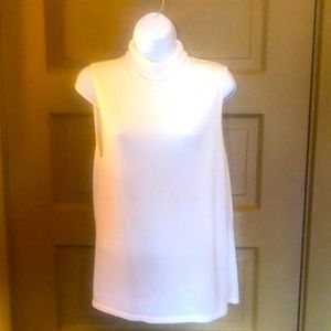Sleeveless white turtleneck. Sag Harbor. Made of acrylic, rayon and nylon.